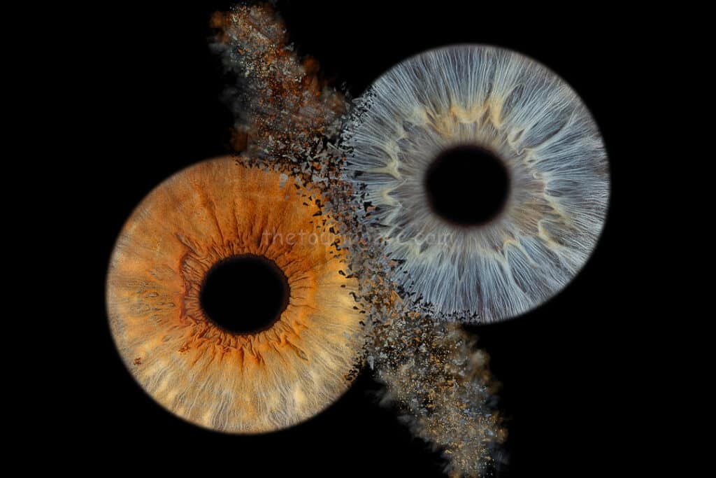 A brown and blue eye irises clash together with debris flying. Iris photography. Eye photography. UK. The Touring Eye